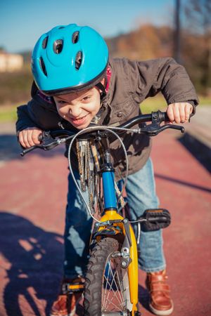 Front of boy making face as he rides his bike