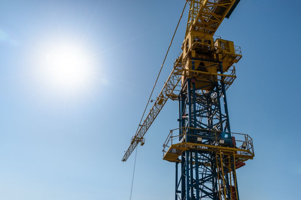 Construction Tower Crane Under a Clear Blue Sky and Bright Sunlight