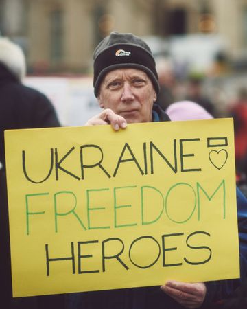 London, England, United Kingdom - March 5 2022: Man holding yellow sign in support of Ukraine