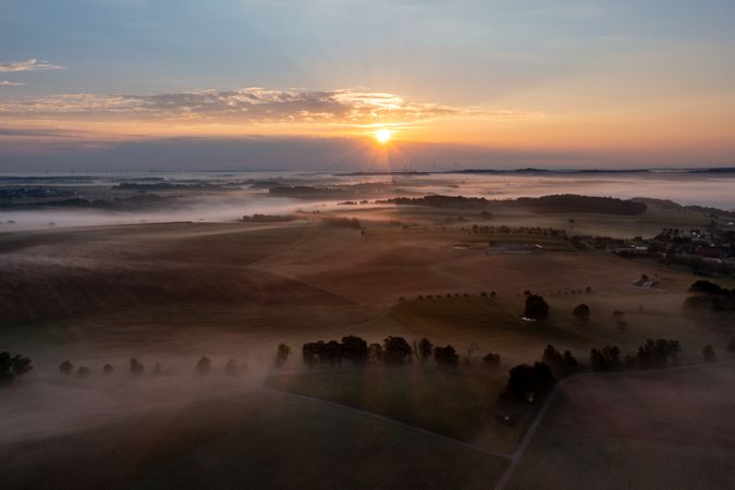 Sunrise aerial view with foggy rolling fields in a german village