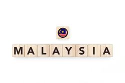 Wooden blocks bearing the name and flag of Malaysia. Malaysian and Southeast Asian Culture, national identity, travel, and geography in a copy space design.