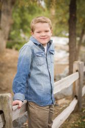 Handsome Young Boy Against Fence in Park