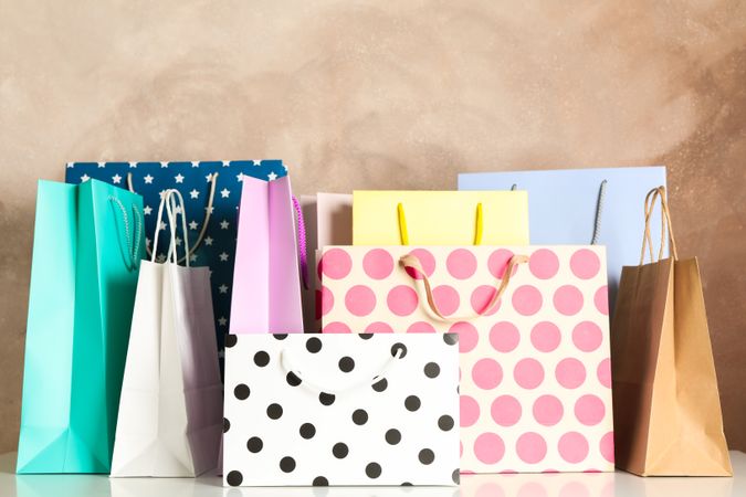 Present bags on table against brown background, copy space