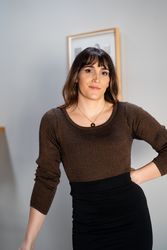Transgender woman posing in office with hand on hip