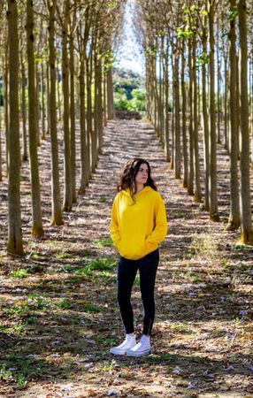 Sporty teenage girl standing in forest