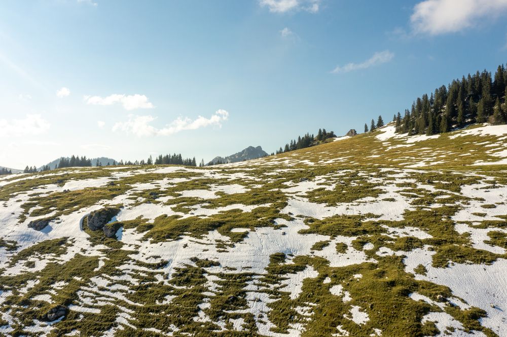 Drone aerial view of snowy pasture in autumn in the Bavarian Alps
