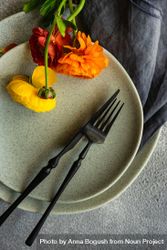 Rustic table setting with ranunculus flowers on grey plate, vertical composition 4d81KD