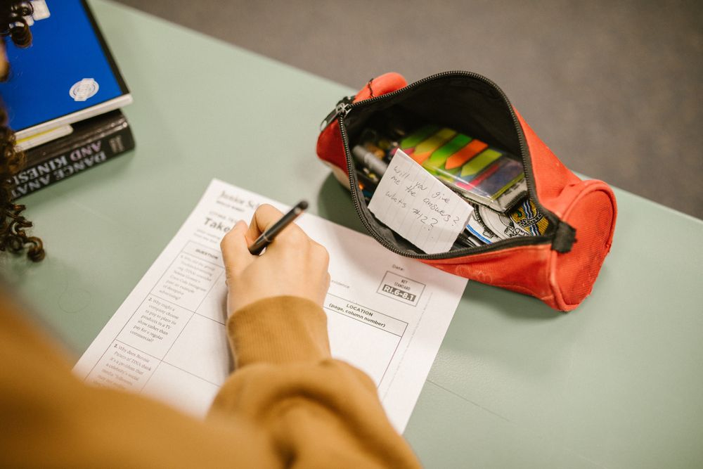 Back view of child writing on a paper