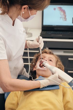Unrecognizable dentist making 3D scanning teeth of boy