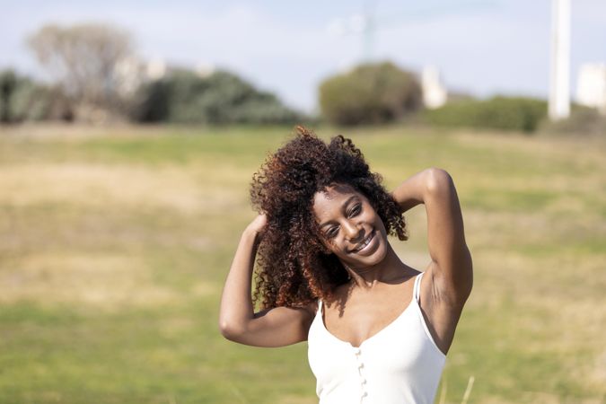 Curly haired female pictured outside in park