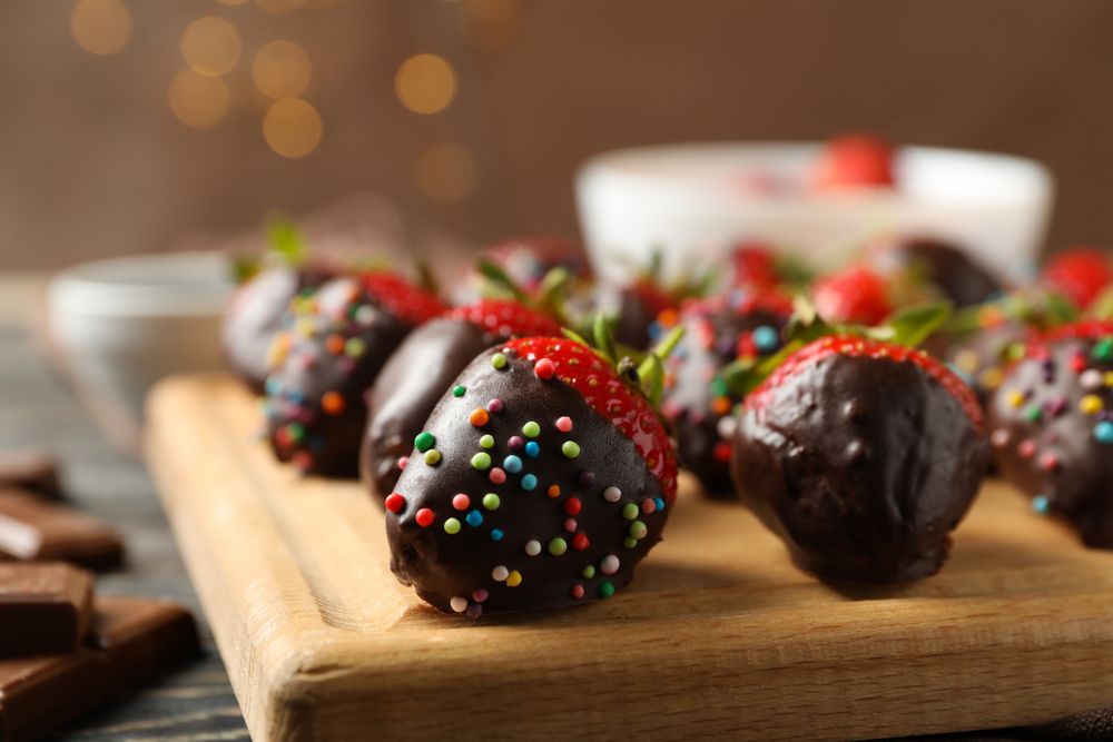 Chocolate fondue. Strawberry in chocolate on wooden background, close up
