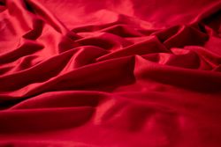 Crumpled wavy Red silky fabric background texture.