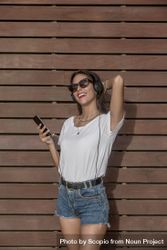 Woman wearing sunglasses and listening to music on headphones 41O6l0