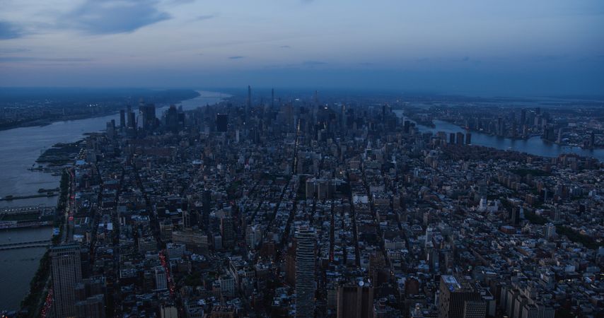 New York City Aerial Evening Cityscape with Stunning Manhattan Landmarks, Skyscrapers and Residential Buildings. Long Wide Angle Panoramic Helicopter View of a Popular Travel Destination