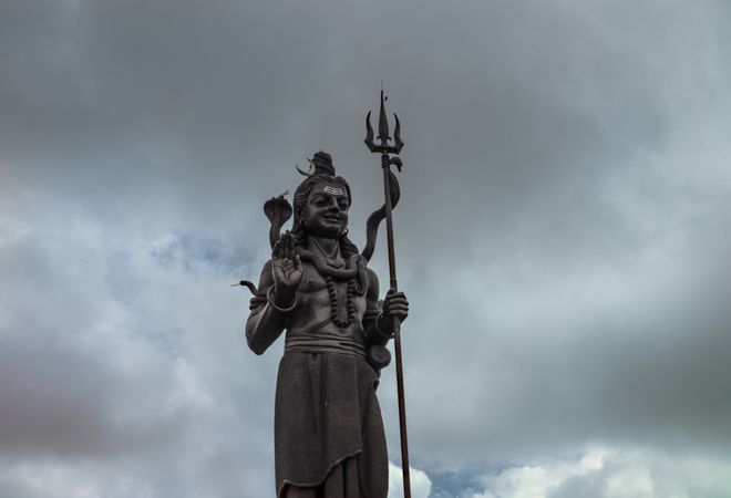 Shiva against a cloudy backdrop