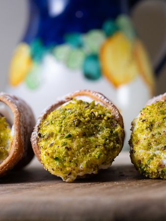 Trio of Sicilian cannoli with pistachio and ricotta on a rustic setting
