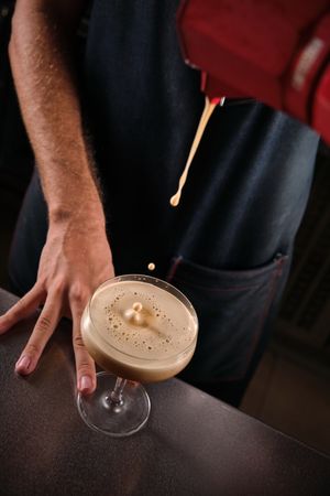 Anonymous male bartender preparing espresso martini cocktail