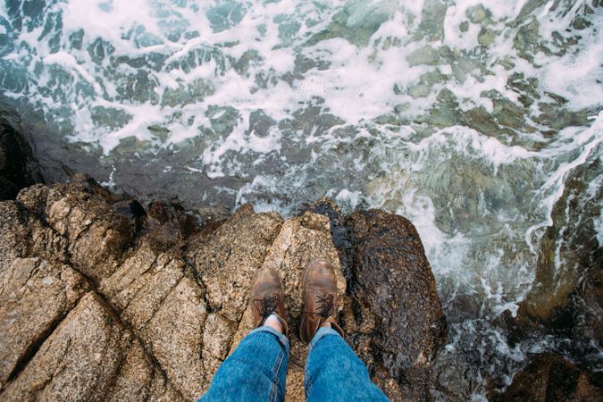 Hiker looking down at coast in leather boots