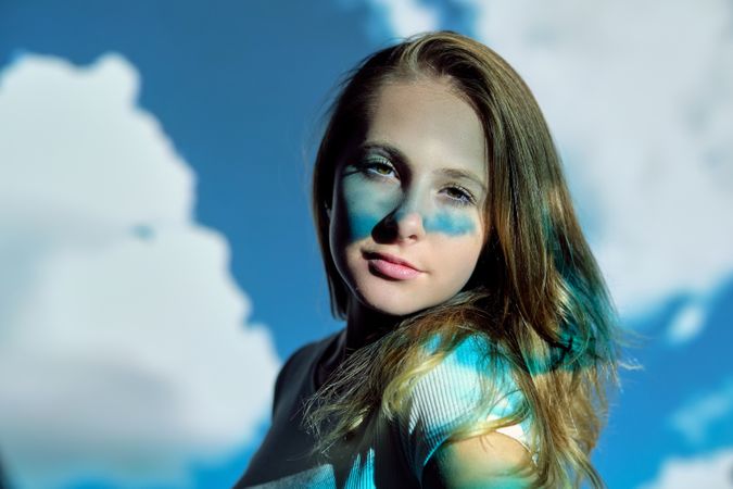 Young female looking at camera against cloudy sky