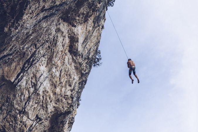 Anonymous climber handing on cliff