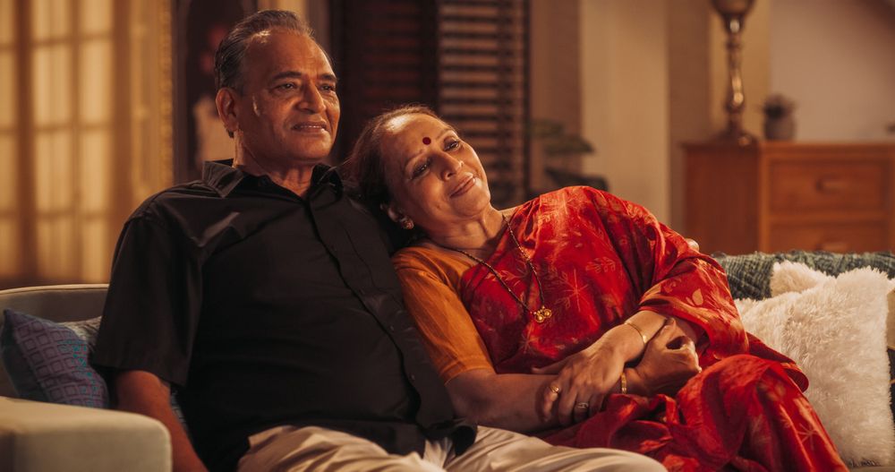 Cozy Time Together: Mature Indian Couple Enjoying a Relaxing Evening at Home, Watching Television, Embrace, Smile.