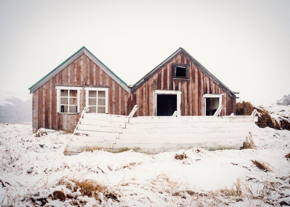 Deserted house between snowy field