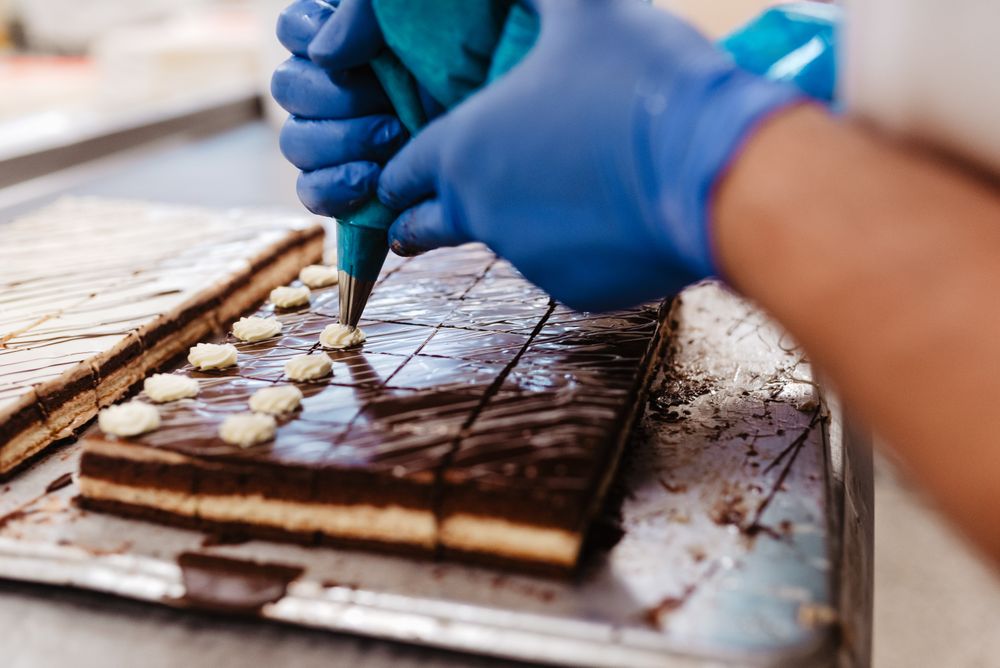 Crop confectioner decorating small cakes
