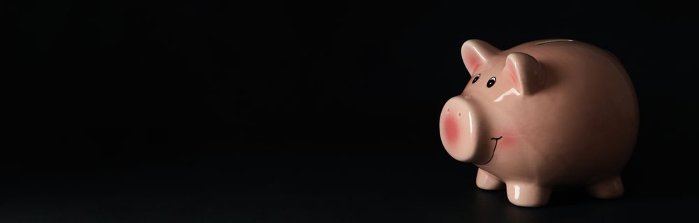 Piggy bank on dark background, space for text