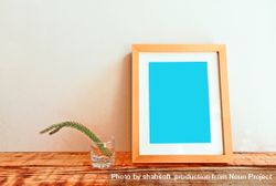 Wooden picture frame on desk with branch mockup 4ZyXO5