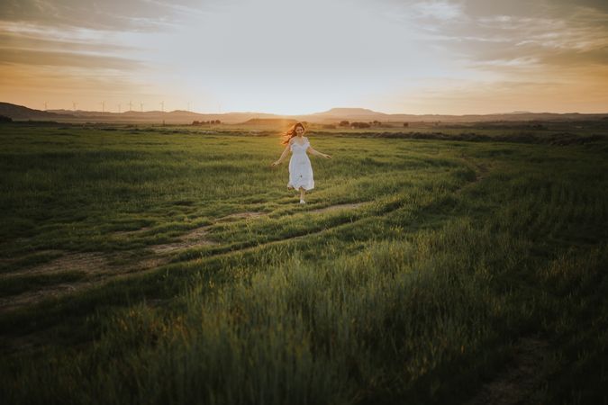 Anonymous woman walking in flower field