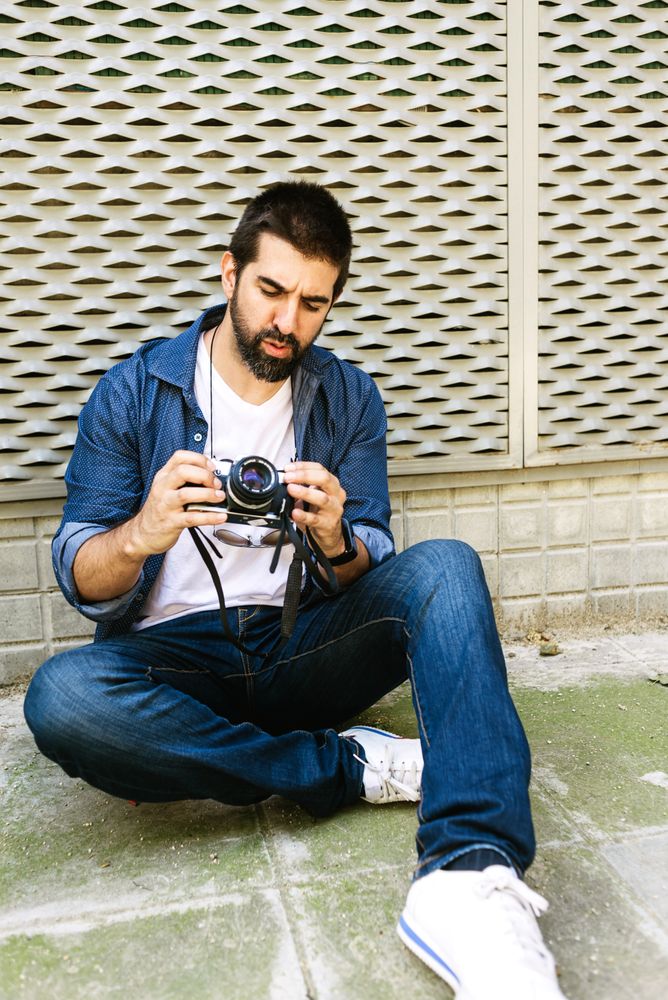 Man in denim setting up camera