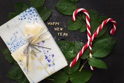 inscription of new year on a board with nice gift and candy-red closeup