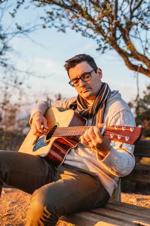 Man playing the guitar on the outside