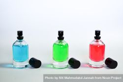Three colorful perfume bottles in a row 0v3qBB