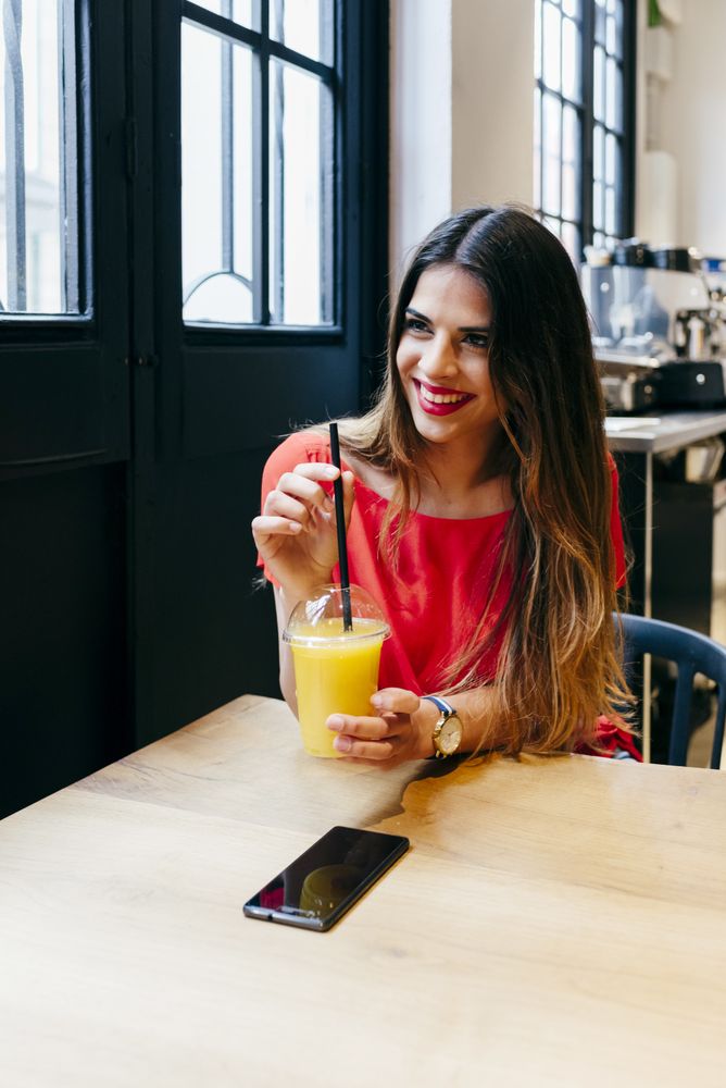 Woman enjoying smoothie in cafe
