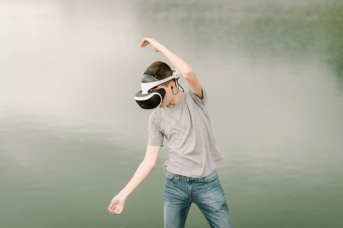 Young teenager with virtual reality glasses outdoors