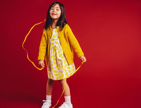 Cute little girl twirling a yellow ribbon