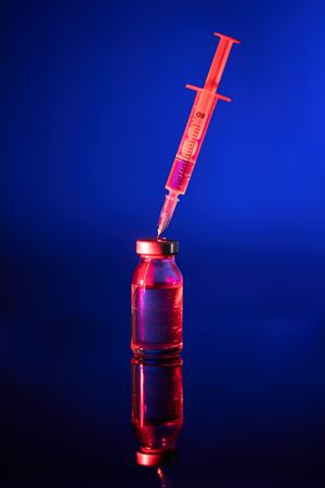 Red vaccine bottle with injection for coronavirus treatment