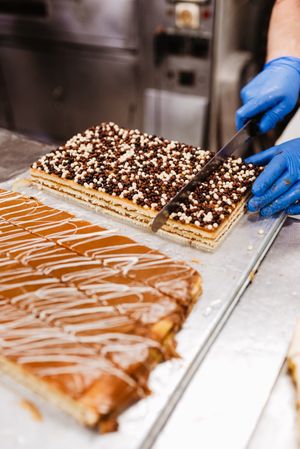 Anonymous cook cutting cake on table