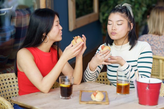 Two women sitting in restaurant patio eating a meal