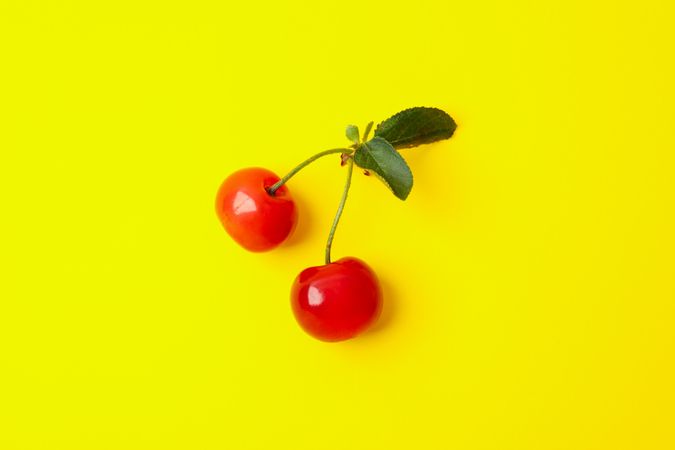 Fresh red cherry on yellow background, close up