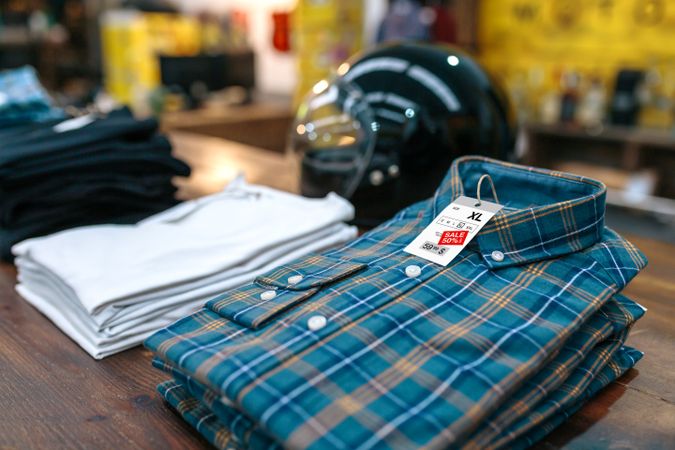 Detail of label with promotion price over a blue plaid shirt on shop with industrial style