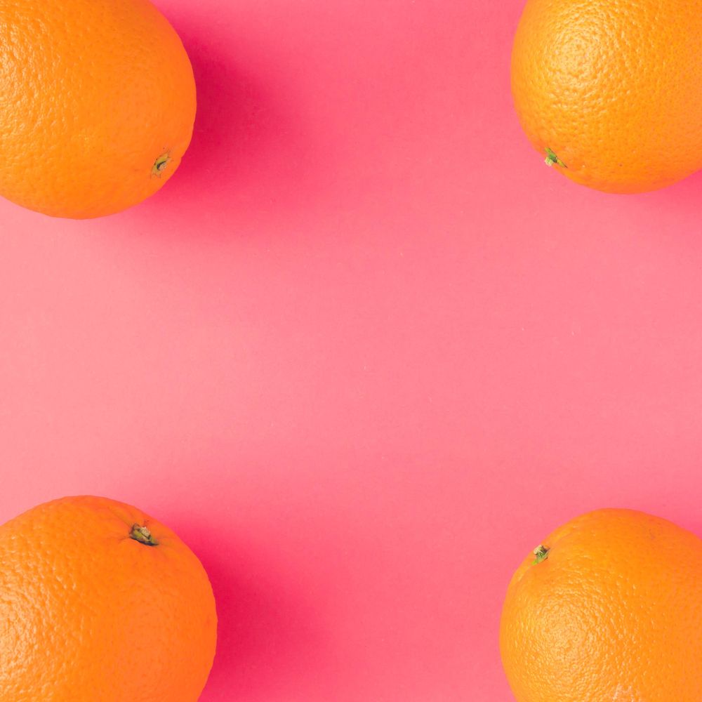 Whole oranges on vivid pink background