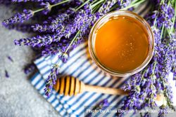 Pot of honey surrounded by lavender bunch 4BamYM