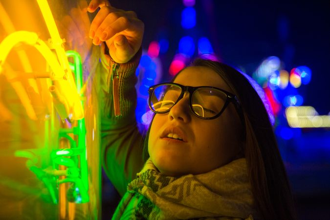 Stylish young woman near illuminated board