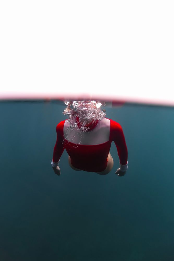 Woman diving in blue waving water