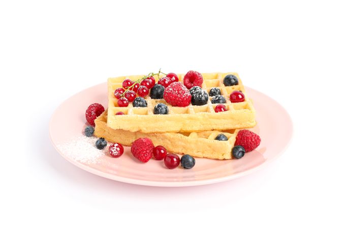 Belgian waffles with berries on plate isolated on blank background