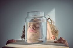 Napping boy near glass jar of water