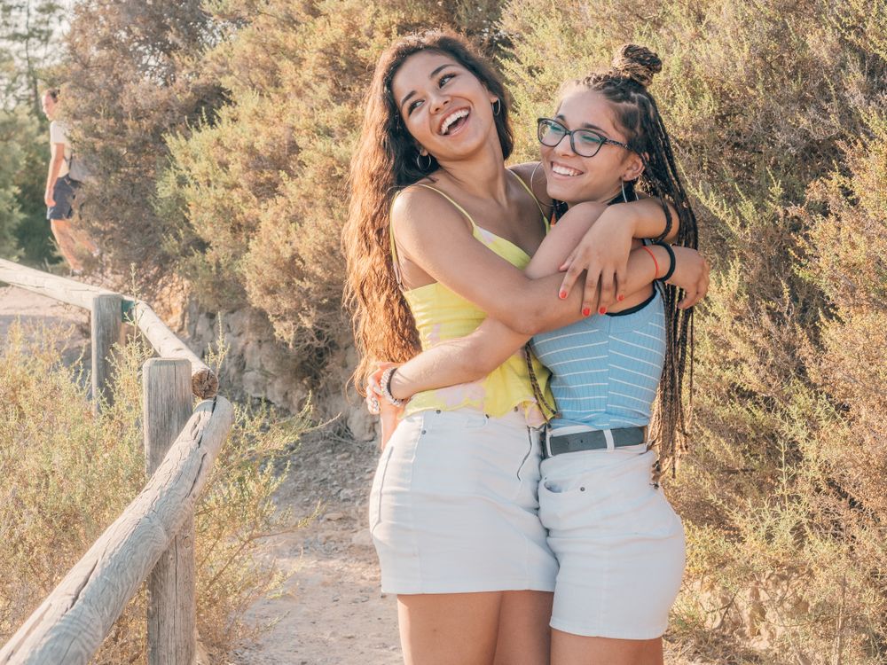 Happy trendy young women bonding at countryside