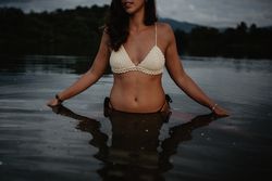 Crop woman standing in lake water